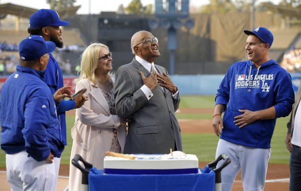 Former Dodgers player Don Newcombe, second from right, reacts as he stands with his wife, Karen, center, manager Dave Roberts, left, Kenley Jansen, second from left, and Joc Pederson, right, as the Dodgers celebrate Newcombe's 90th birthday prior to a baseball game against the Colorado Rockies, in L.A., on June 8, 2016. (Mark J. Terrill/AP)