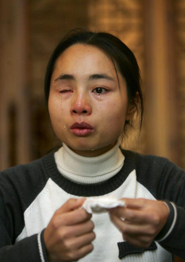 Xia Hongyu breaks down in tears as she talks about the loss of her eye in Beijing on Dec. 6, 2006. Xia is from Hubei Province, her right eyeball was allegedly dug out by her husband with a screwdriver on Dec. 10, 2003. (China Photos/Getty Images)
