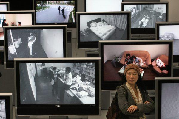 A Chinese woman stands next to videos showing domestic violence and marriage breakdowns at an exhibition in Shanghai, China on March 15, 2007. (Mark Ralston/AFP/Getty Images)