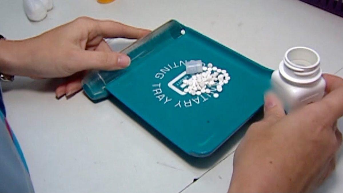 Medical staff putting prescription opioid medication on a tray. (image via CNN)