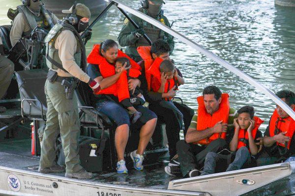 Illegal border crossers are rescued by agents on a U.S. Customs and Border Protection boat as they get stuck halfway across the Rio Grande from Mexico into Eagle Pass, Texas, on Feb. 16, 2019. (Charlotte Cuthbertson/The Epoch Times)