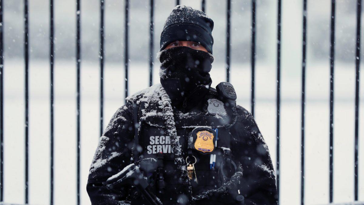 A snow-covered member of the Secret Service keeps watch in front of the White House in Wash., on Feb. 20, 2019. (Kevin Lamarque/Reuters)