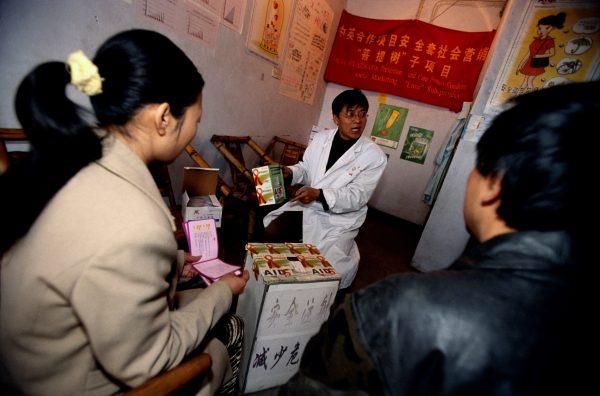 A doctor from the local Center for Disease Control dispenses advice on a needle exchange program to addicts in Cheng Du, China on Nov. 26, 2004. The woman on the right is also a sex worker and she learns about STD's and HIV at this clinic as well as the dangers of sharing needles. (Brent Stirton/Getty Images)