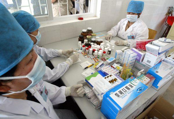 Medical personnel wait to distribute an assortment of drugs for treatment at an HIV/AIDS clinic in Wenlou, central China, on May 28, 2004. (Frederic Brown/AFP/Getty Images)
