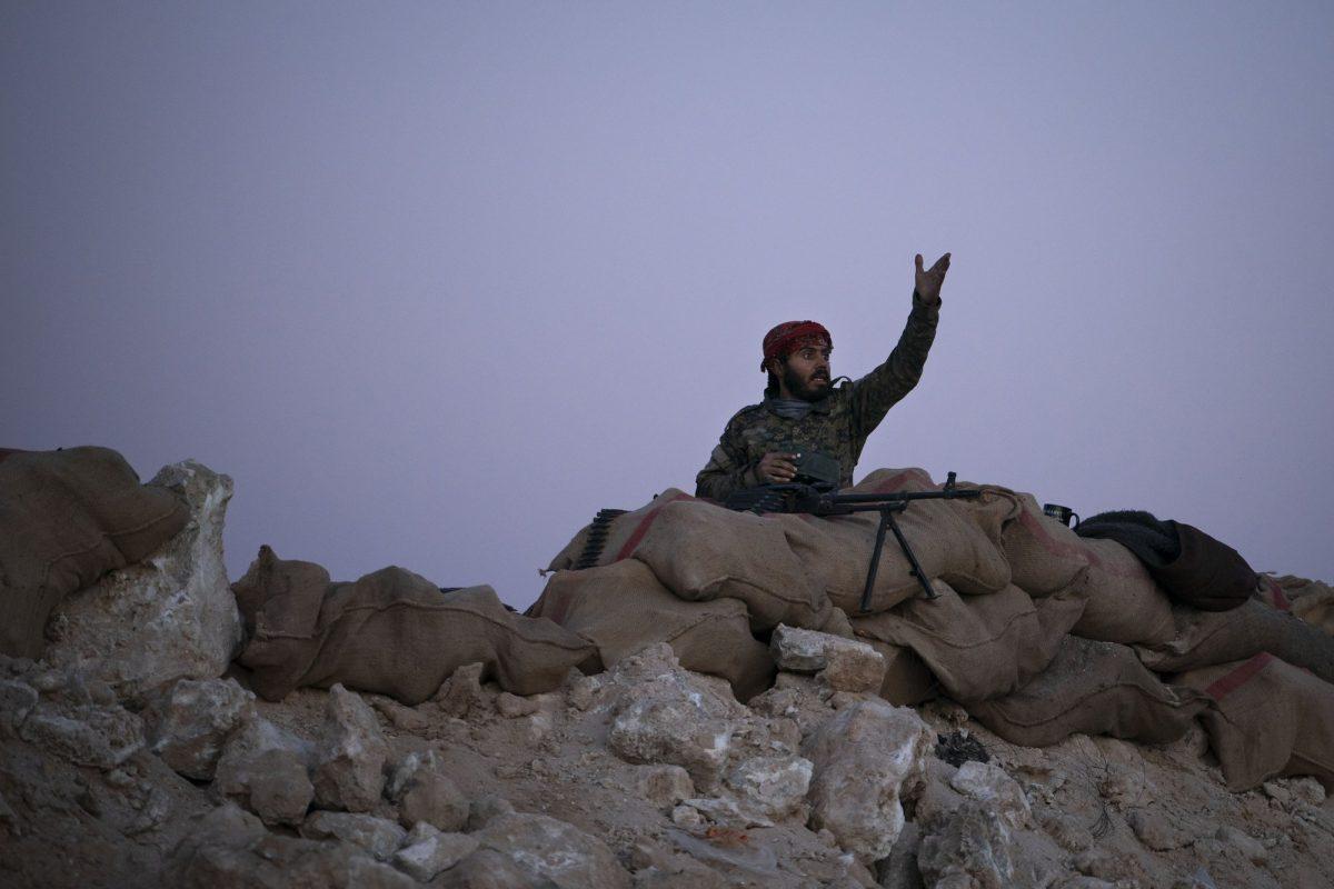 A U.S.-backed Syrian Democratic Forces (SDF) fighter reacts as an airstrike hits territory still held by Islamic State militants in the desert outside Baghouz, Syria, on Feb. 19, 2019. (Felipe Dana/AP Photo)