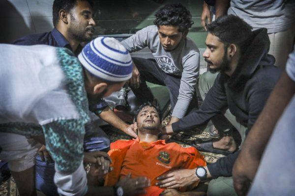 Locals help a Bangladeshi firefighter who got unconscious for a while, while trying to douse flames of a smoldering fire in a building in Dhaka, Bangladesh, on Feb. 21, 2019. (Photo/AP)