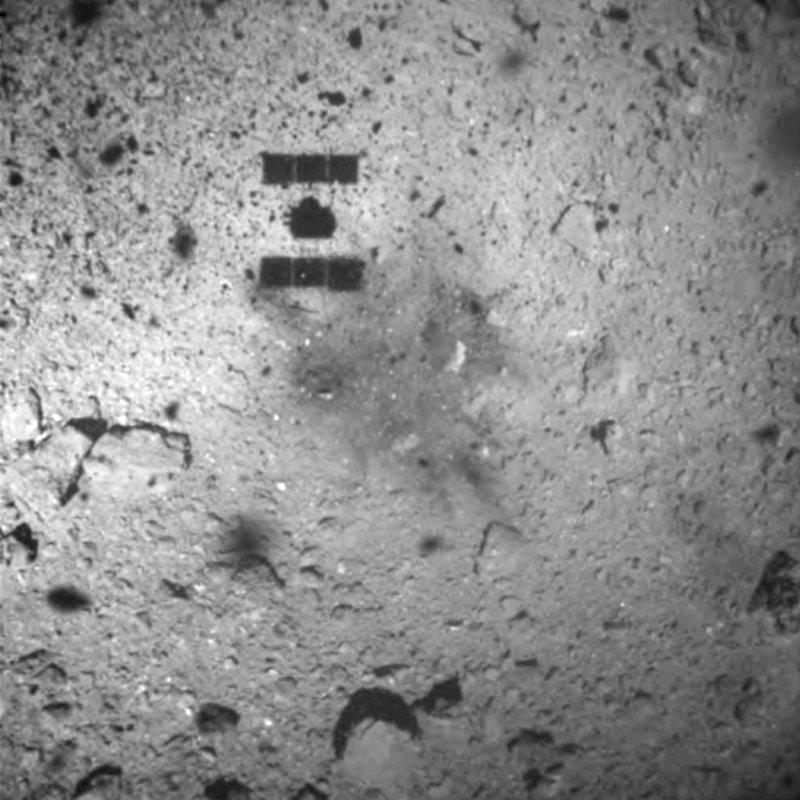 This image released by the Japan Aerospace Exploration Agency (JAXA) shows the shadow, center above, of the Hayabusa2 spacecraft after its successful touchdown on the asteroid Ryugu, on Feb. 22, 2019. (JAXA via AP)