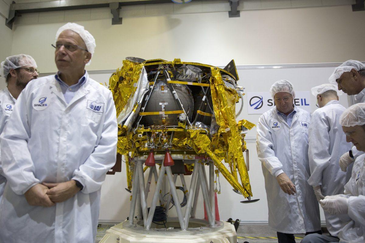 Technicians stand next to the SpaceIL lunar module, an unmanned spacecraft, on display in a special clean room during a press tour of their facility near Tel Aviv, Israel, on Dec. 17, 2018. (Ariel Schalit/AP Photo)