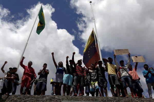People waiting to cross to Venezuela gesture at the border between Venezuela and Brazil in Pacaraima, Roraima state, Brazil, on Feb. 22, 2019. (Ricardo Moraes/Reuters)