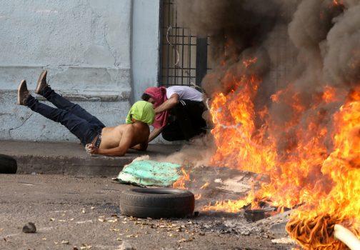 A demonstrator lies on the ground after hitting a barbed wire while clashing with security forces in Ureña, Venezuela, on Feb. 23, 2019. (Andres Martinez Casares/Reuters)