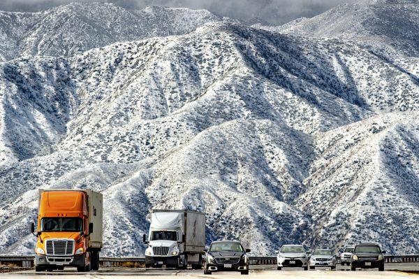 Mountains are blanketed with snow as traffic makes its way slowly through Cajon Pass on the I-15 near Hwy 138 in Phelan, Calif., on Feb. 21, 2019. (Watchara Phomicinda/The Orange County Register via AP)