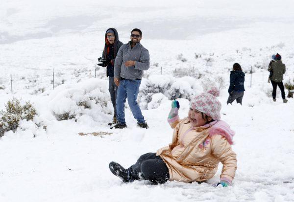 Valentina Gonzalez, 7, laughs after falling during a snowball fight with her family at the Red Rock Canyon National Conservation, west of Las Vegas, on Feb. 21, 2018. (Steve Marcus/Las Vegas Sun via AP)