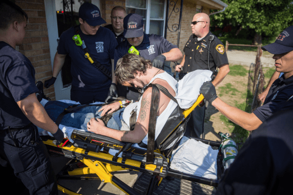 Local police, the fire department, and deputy sheriffs help a man who is overdosing in the Drexel neighborhood of Dayton, Ohio, on Aug. 3, 2017. (Benjamin Chasteen/The Epoch Times)