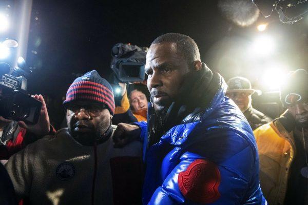 R. Kelly surrenders to authorities at Chicago First District police station, on Feb. 22, 2019. R&B star R. Kelly was taken into custody after arriving Friday night at a Chicago police precinct, hours after authorities announced multiple charges of aggravated sexual abuse involving four victims, including at least three between the ages of 13 and 17. (Tyler LaRiviere/Chicago Sun-Times via AP)