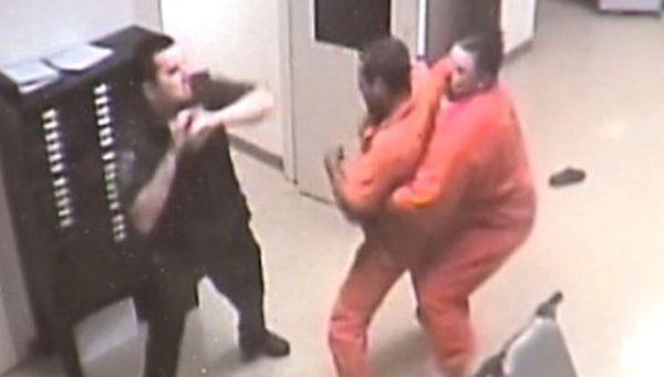 The other, larger inmate restrains the prisoner (YouTube / Payne County)