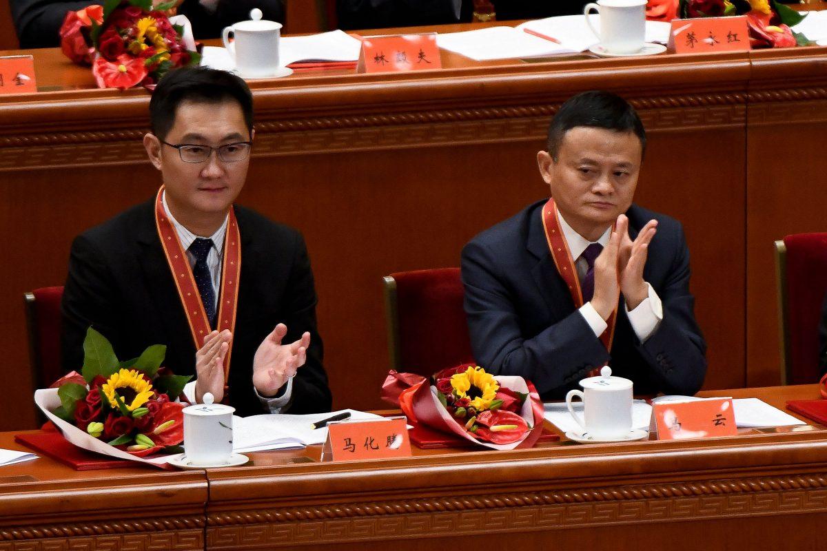 Alibaba's co-founder Jack Ma (R) and Tencent Holdings' CEO Pony Ma applaud during a celebration meeting marking the 40th anniversary of China's "reform and opening up" policy at the Great Hall of the People in Beijing, on Dec. 18, 2018. (Wang Zhao/AFP/Getty Images)
