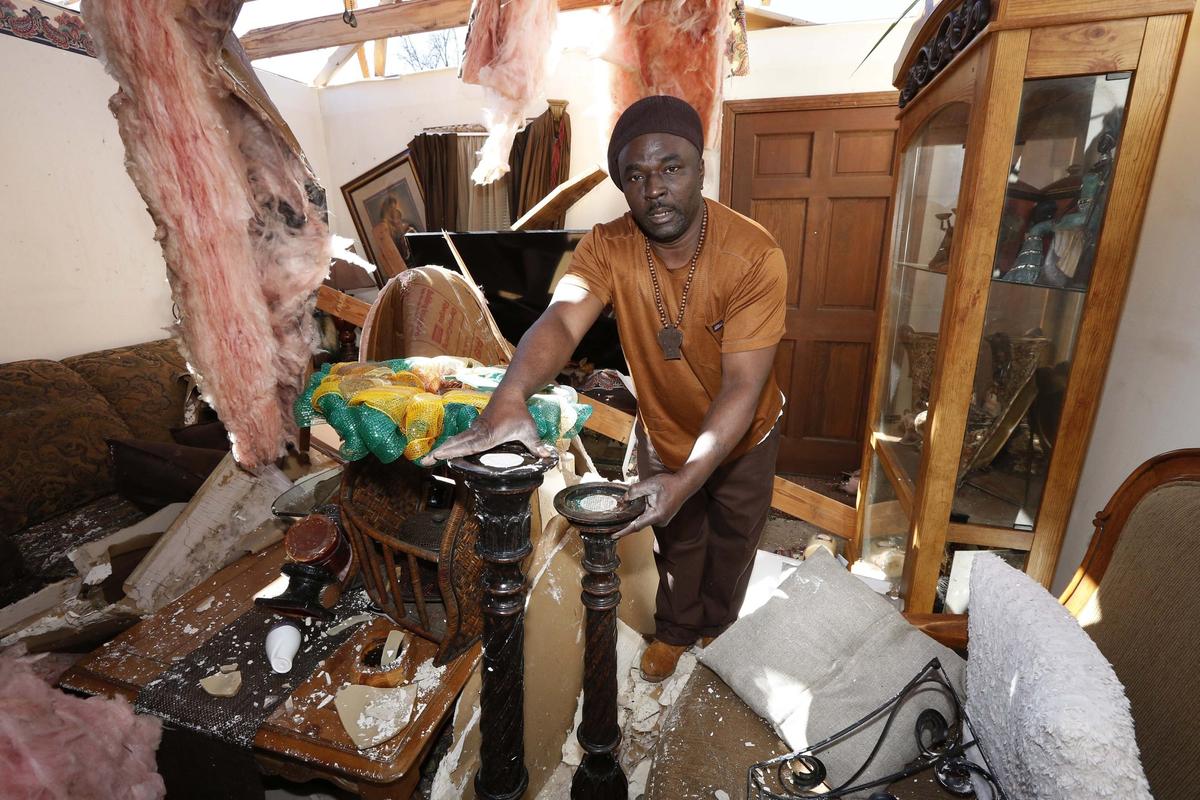 Charles Lowery of Columbus, Miss., rescues carved stands from the remains of his home, Sunday, Feb. 24, 2019, following Saturday's tornado. Lowery lamented not staying at home and protecting his property as his home was looted that evening. (AP Photo/Rogelio V. Solis)