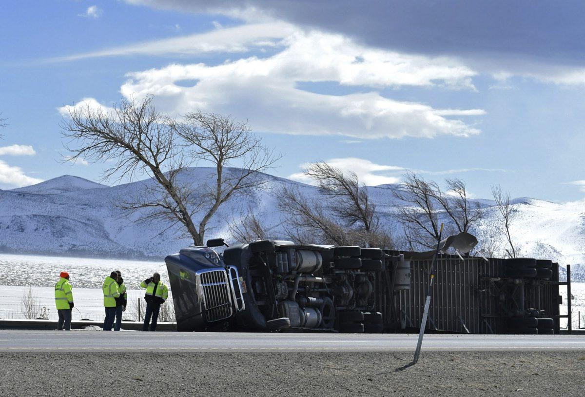 Nevada Department of Transportation officials tend to a rolled over high profile vehicle on the Interstate 580 south of Reno, Nev., Feb 25, 2019. (Andy Barron/Reno Gazette-Journal via AP)