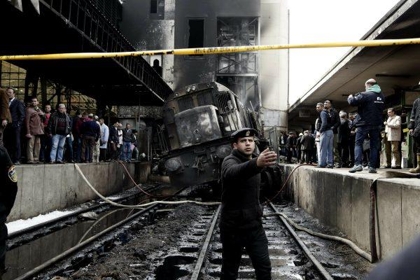 Policemen stand guard in front of a damaged train inside Ramsis train station in Cairo, Egypt, on Feb. 27, 2019. (Nariman El-Mofty/AP)