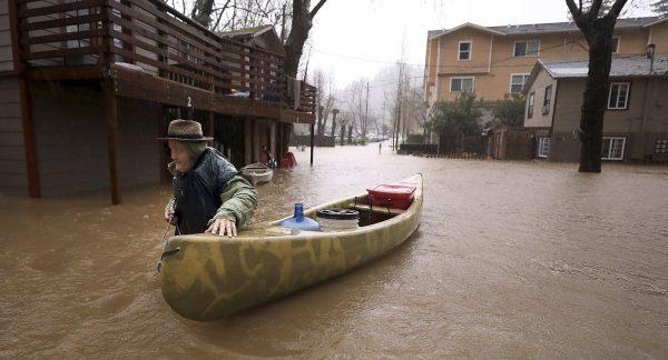 Sycamore Court resident Jesse Hagan evacuates to higher ground in the apartment complex in lower Guerneville, Calif., on Feb. 26, 2019. (Kent Porter/The Press Democrat via AP)