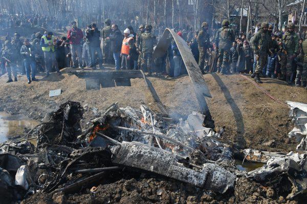 Indian soldiers and Kashmiri onlookers stand near the remains of an Indian Air Force helicopter after it crashed in Budgam district, on the outskirts of Srinagar on Feb. 27, 2019. (Tauseef Mustafa/AFP/Getty Images)