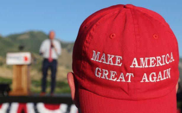 A man listens to a speaker as he wears a "Make America Great Again" hat at an election party in Orem, Utah, on June 26, 2018. (George Frey/Getty Images)