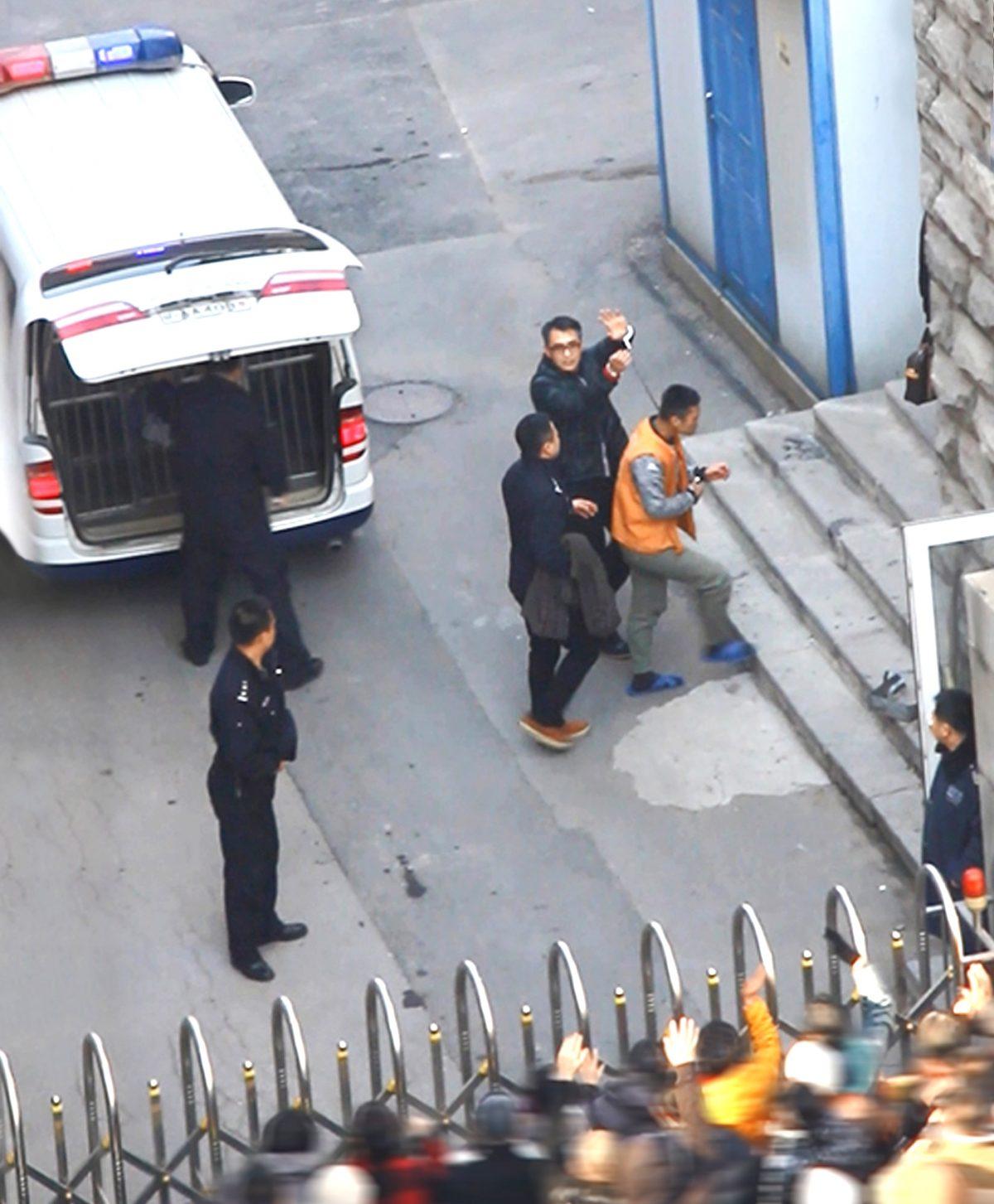 Yu Ming, holding up his handcuffed hands, arrives at the court in Shenyang City on Nov. 20, 2014. (Minghui.org)