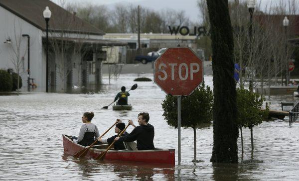 People paddle and row through the flooded Barlow Market District in Sebastopol, Calif., on Feb. 27, 2019. (Eric Risberg/AP)