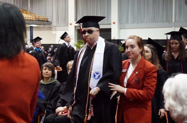 Joel Tavera walking during his graduation from the University of Tampa Dec. 15, 2018. (Gary Dejidas)