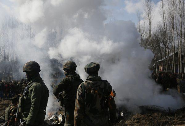 Indian army soldiers stand near the wreckage of an Indian helicopter after it crashed in Budgam area, outskirts of Srinagar, Indian controlled Kashmir, Wednesday, Feb.27, 2019. (AP Photo/Mukhtar Khan)
