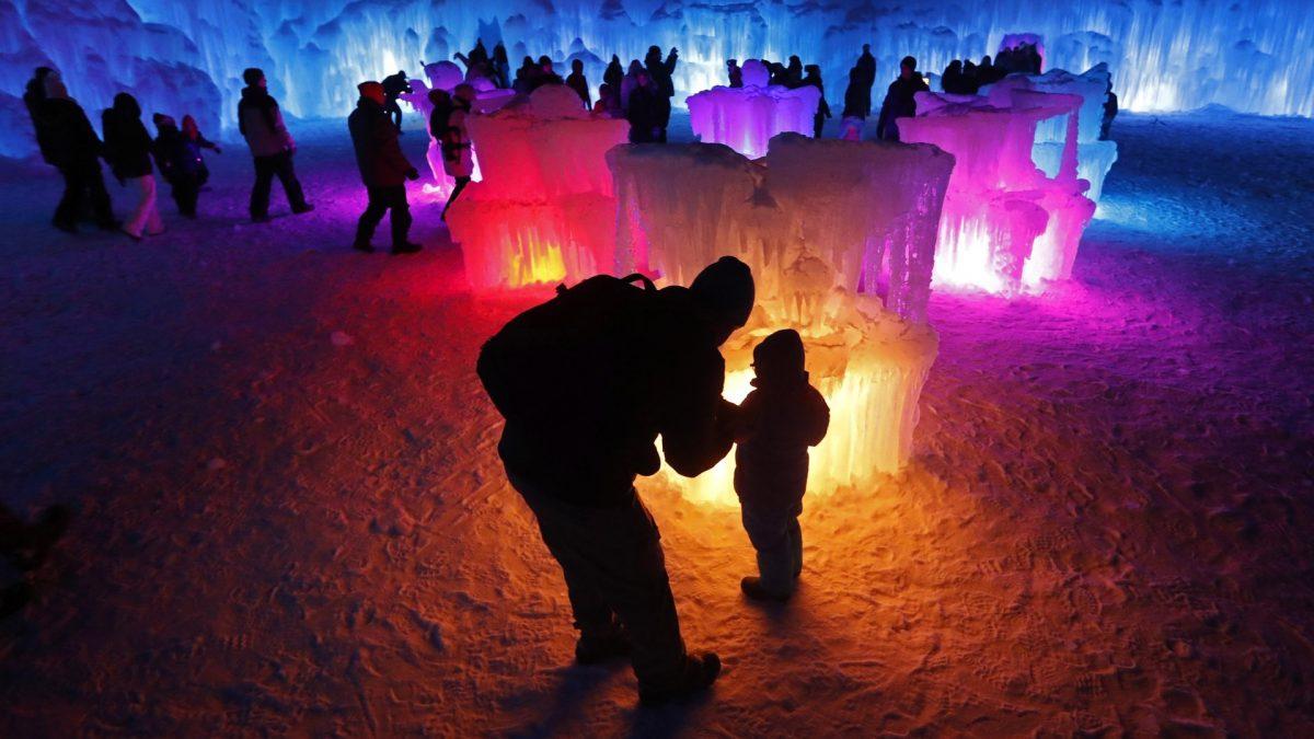 Bruce McCafferty and his son, Dougie, pause while exploring the ice formations growing at Ice Castles in North Woodstock, N.H., on Jan. 26, 2019. (Robert F. Bukaty/AP Photo)