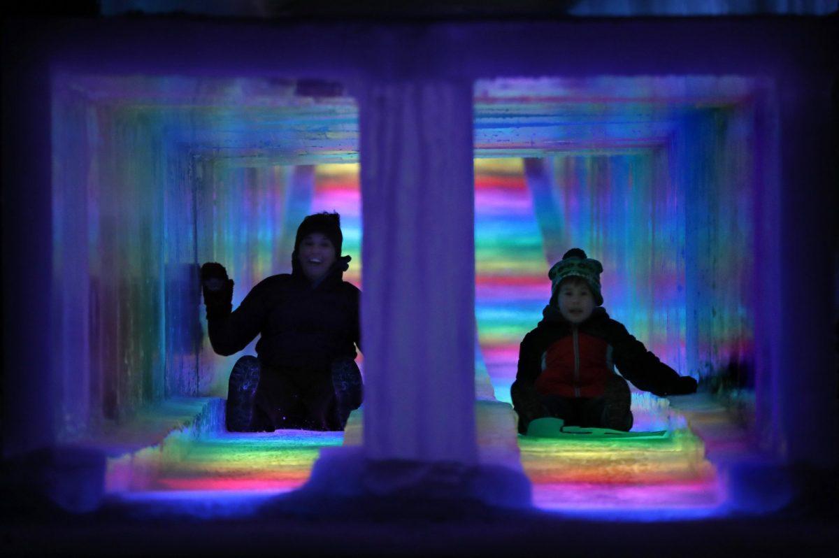 Visitors race down the side-by-side tunnels of a 97-foot ice slide at Ice Castles in North Woodstock, N.H., on Jan. 25, 2019. The winter wonderland is one of six in North America. (Robert F. Bukaty/AP Photo)