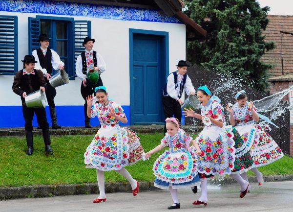 Local school girls in traditional clothes of the Kalocsa area react as boys throw water in Kalocsa, some 100 km south of Budapest on April 17, 2014, during a rehearsal of the traditional Easter celebrations by the members of the local folk dance group. Locals from south Hungary celebrate Easter with the traditional "watering of the girls," a fertility ritual rooted in Hungary's tribal pre-Christian past, going as far back as the second century. (©Getty Images | <a href="https://www.gettyimages.com/detail/news-photo/some-local-school-girls-in-traditional-clothes-of-the-news-photo/485281409">Attila Kisbenedek/AFP</a>)