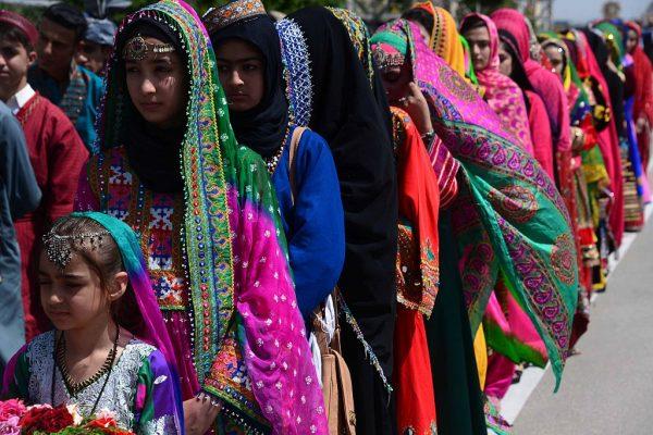 Afghan women and girls wearing traditional Afghanistan clothes wait for the arrival of Afghan President Ashraf Ghani, a day before the inauguration of Salma Hydroelectric Dam, at the airport in Herat on June 3, 2016. (©Getty Images | <a href="https://www.gettyimages.com/detail/news-photo/afghan-women-and-girls-wearing-traditional-afghanistan-news-photo/537796314">Aref Karimi/AFP</a>)