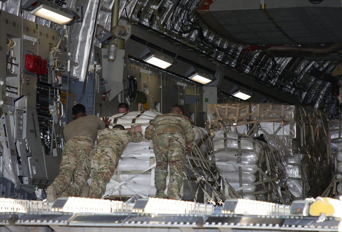 U.S. military personnel load a C-17 cargo plane with food, water, and medicine for a humanitarian mission to Colombia to aid Venezuelans at the Homestead Air Force Base in Homestead Florida on Feb. 22, 2019. (RHONA WISE/AFP/Getty Images)