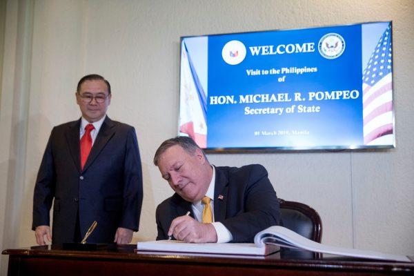 U.S. Secretary of State Mike Pompeo signs a guest book as he arrives to meet with Philippines Foreign Secretary Teodoro Locsin Jr., left, at the Philippines Department of Foreign Affairs Home Office in Manila, Philippines on March 1, 2019. (Andrew Harnik/Pool via Reuters)