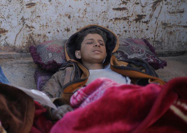 Hareth Najem, an Iraqi orphan lies under a blanket in a truck, near the village of Baghouz, Deir Al Zor province, Syria on March 1, 2019. (Rodi Said/Reuters)