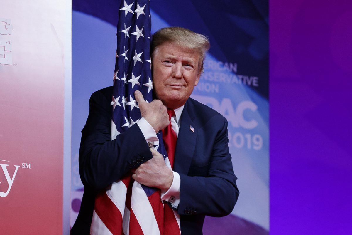 President Trump hugs the American flag as he arrives to speak at Conservative Political Action Conference, CPAC 2019, in Oxon Hill, Md., on March 2, 2019. (Carolyn Kaster/AP Photo)