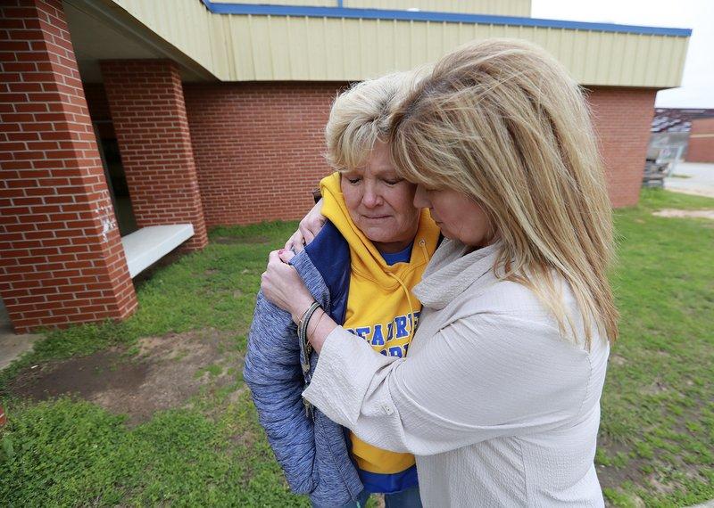 Beauregard High School teachers Julie Howard (L) and Michelle Johnson (R) console each other outside the school gymnasium as they prepare to attend a prayer circle at the school for those who lost their lives in a tornado the day before, in Beauregard, Ala., on March 4, 2019. (Curtis Compton/Atlanta Journal-Constitution via AP)