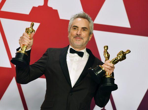 Alfonso Cuaron poses with the awards for best director for "Roma," best foreign language film for "Roma," and best cinematography for "Roma" in the press room at the Oscars at the Dolby Theatre in Los Angeles, on Feb. 24, 2019. (Jordan Strauss/Invision/AP, File)