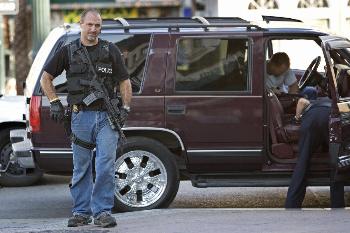 A Drug Enforcement Administration officer secures the area as police search a suspect's car in New Orleans in August 2007. (PAUL J. RICHARDS/AFP/Getty Images)