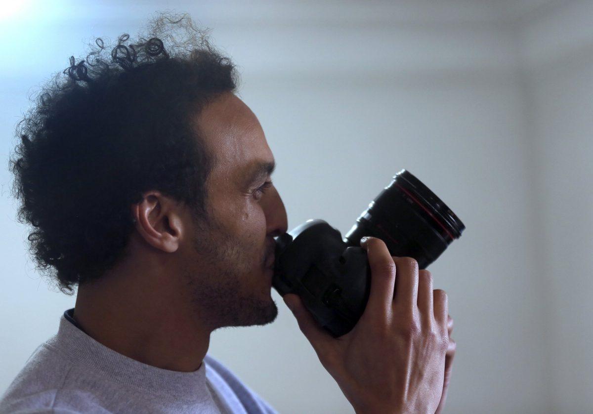 Mahmoud Abu Zaid, a photojournalist known as Shawkan, kisses his colleague's camera at his home in Cairo, Egypt, on March 4, 2019. (Amor Nabil/AP Photo)