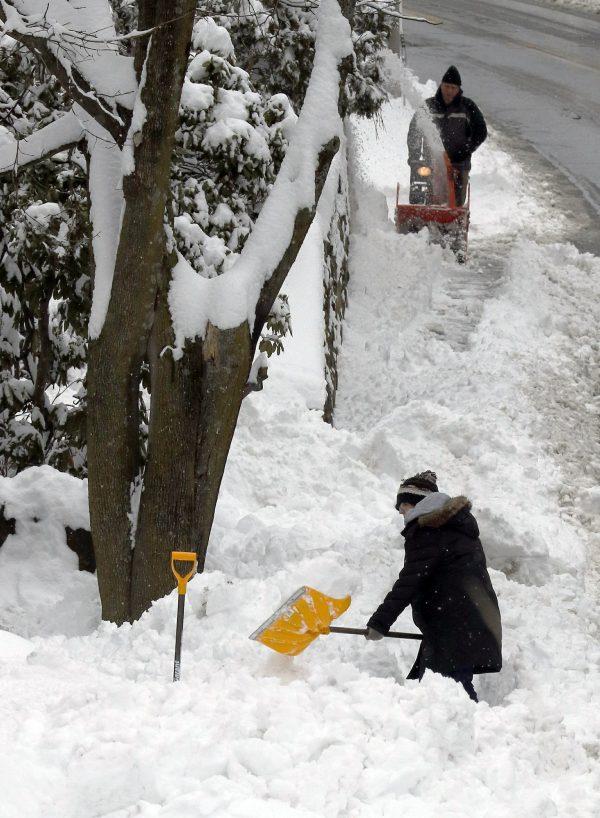 Residents clear snow after an overnight snowstorm dropped nearly a foot of snow in Marlborough Mass on March 4, 2019. (AP Photo/Bill Sikes)