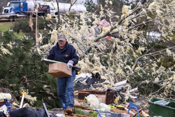 A man salvages belongings near Beauregard, Ala., on March 4, 2019. (Mickey Welsh/Montgomery Advertiser via AP)