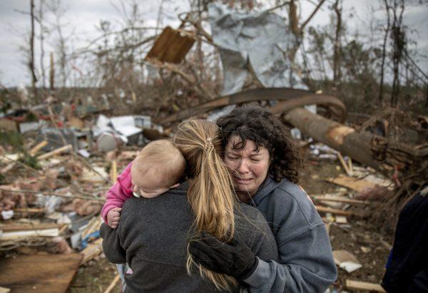 Carol Dean (R) cries while embraced by Megan Anderson and her 18-month-old daughter Madilyn, as Dean sifts through the debris of the home she shared with her husband, David Wayne Dean, who died when a tornado destroyed the house in Beauregard, Ala., on March 4, 2019. (David Goldman/AP Photo)