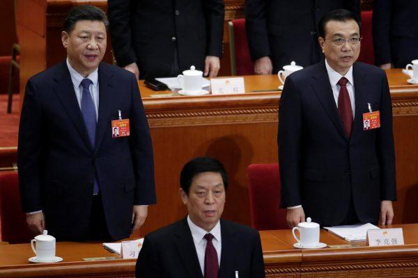 Chinese leader Xi Jinping, Chinese Premier Li Keqiang and Li Zhanshu, chairman of the Standing Committee of the National People's Congress (NPC), sing the national anthem during the opening session of the NPC at the Great Hall of the People in Beijing on March 5, 2019. (Jason Lee/Reuters)