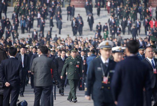A military officer and other delegates leave after a preliminary meeting ahead of National People's Congress (NPC), China's annual meeting of the Chinese Communist Party's political advisory body, at the Great Hall of the People in Beijing on March 4, 2019. (Jason Lee/Reuters)