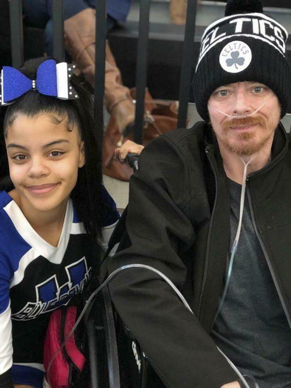 Photo provided by Bridgette Hoskie, her daughter Tianna Greene and brother Jay Barrett pose for a photo at a cheerleading competition in New Haven, Conn., on March 3, 2019. (Bridgette Hoskie via AP)