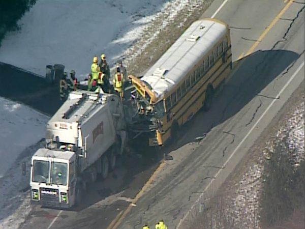 Image made from a video provided by WCPO-TV, a school bus collides with a garbage truck near Aurora, Ind, a city about 30 miles west of Cincinnati, on March 6, 2019. Authorities say multiple students were hurt in the accident. (WCPO-TV via AP)