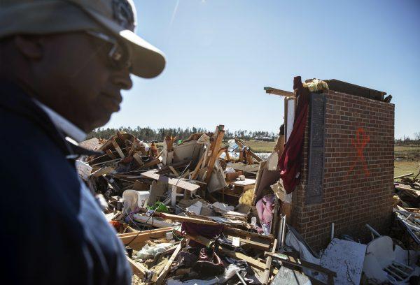 Bernard Reese stands next to the rubble of his aunt's home in which she survived a tornado as he helps retrieve personal items in Beauregard, Ala., Tuesday, March 5, 2019. (AP Photo/David Goldman)